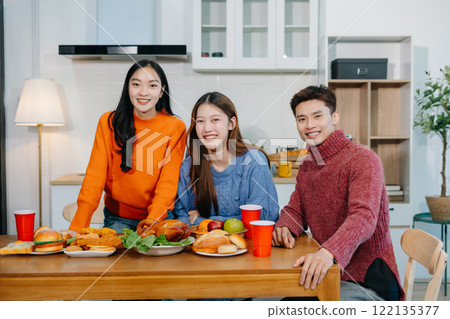 Drinks and conversation, social gathering and get together. Young people, eating pizza and happiness, celebration at home. Drinks and conversation, social gathering and get together. Young people, eating pizza and happiness, celebration at home. 122135377