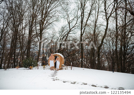 Elderly couple coming out of sauna after a sauna session. Winter spa weekend getaway for elderly people. Elderly couple coming out of sauna after a sauna session. Winter spa weekend getaway for elderly people. 122135494