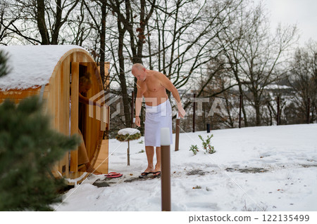 Senior couple entering small sauna. Winter spa weekend getaway for elderly people. Senior couple entering small sauna. Winter spa weekend getaway for elderly people. 122135499