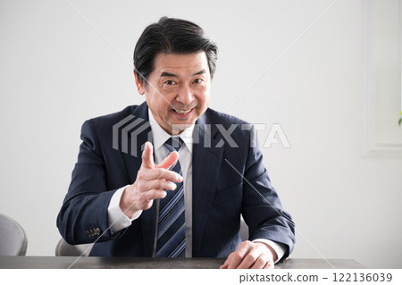 A man making a pose of decision, such as "I've decided on this!" or "That's it!" Smiling during a sales meeting or business negotiation 122136039