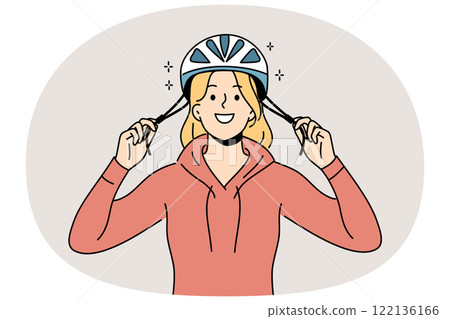 Woman cyclist puts protective helmet on head before cycling to protect against injuries from falls 122136166