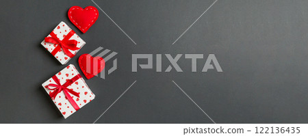 Holiday composition of gift boxes and red textile hearts on colorful background with empty space for your design. Top view of Valentine's Day concept 122136435