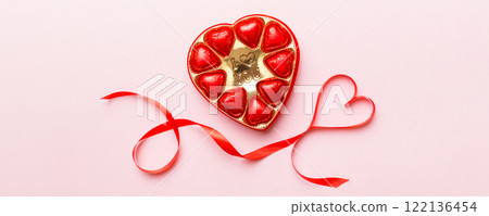Delicious chocolate pralines in red box for Valentine's Day. Heart shaped box of chocolates top view with copy space 122136454