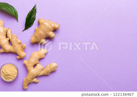 Finely dry Ginger powder in bowl with green leaves isolated on colored background. top view flat lay 122136467