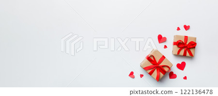 Valentine day composition: red gift box with bow and heart. Christmas present. View from above. Space for text. Holday greeting card 122136478