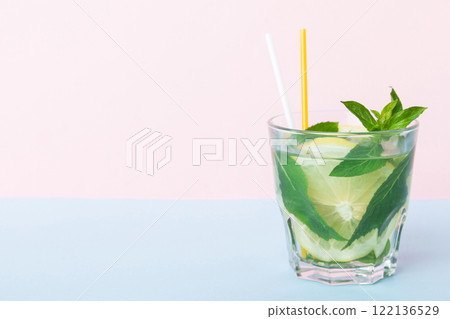 Mojito summer refreshing cocktail with ice and mint. mojito cocktail with lime, lemon and mint in a tall glass with a stick 122136529