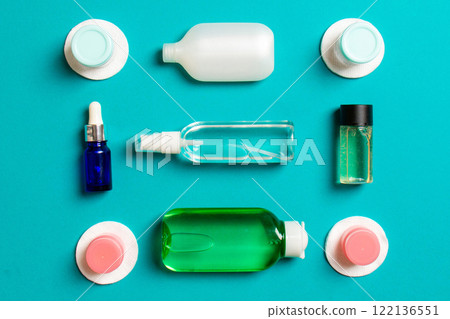 Set of travel size cosmetic bottles on colored background. Flat lay of cream jars. Top view of bodycare style concept 122136551