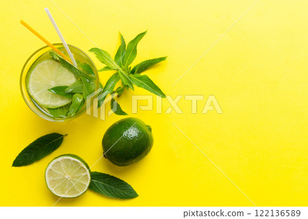 Caipirinha, Mojito cocktail, vodka or soda drink with lime, mint and straw on table background. Refreshing beverage with mint and lime in glass top view flat lay 122136589