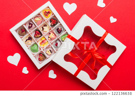 Valentine day composition: sweet candy, with gift boxes with bow and red felt hearts, photo template, background. Top View with copy space Valentine day composition: sweet candy, with gift boxes with bow and red felt hearts, photo template, background. Top View with copy space 122136638