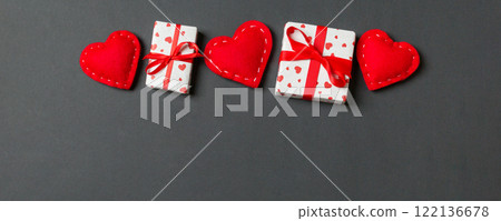 Holiday composition of gift boxes and red textile hearts on colorful background with empty space for your design. Top view of Valentine's Day concept 122136678