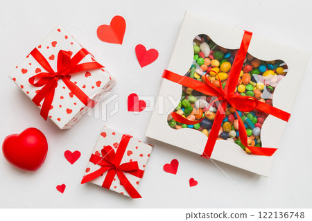 Valentine day composition: sweet candy, with gift boxes with bow and red felt hearts, photo template, background. Top View with copy space 122136748