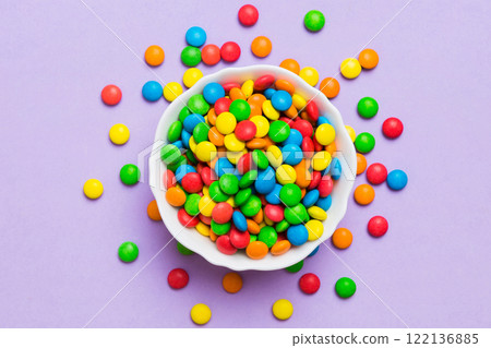 Multicolored candies in a bowl on a colored background. birthday and holiday concept. Top view with copy space Multicolored candies in a bowl on a colored background. birthday and holiday concept. Top view with copy space 122136885