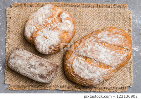Assortment of freshly baked bread with napkin on rustic table top view. Healthy unleavened bread. French bread 122136902