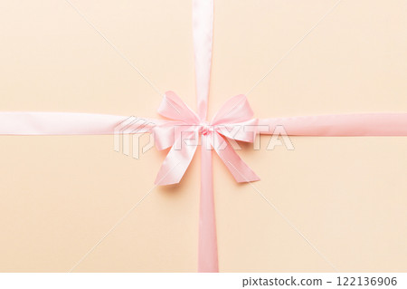 Top view of purple ribbon rolled and pink bow isolated on colored background. Flat lay with copy space Top view of purple ribbon rolled and pink bow isolated on colored background. Flat lay with copy space 122136906