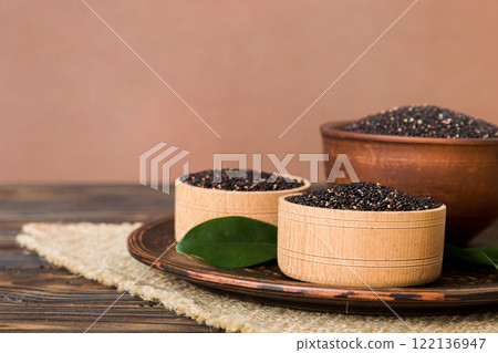 quinoa seeds in bowl on colored background. Healthy kinwa in small bowl. Healthy superfood quinoa seeds in bowl on colored background. Healthy kinwa in small bowl. Healthy superfood 122136947