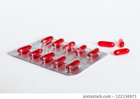 Blister package with Vitamin a on color background. Medicine pills on a light background. Medicines and prescription pills flat lay background. red medical tablets in blister 122136971