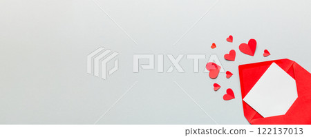 Red paper envelope with empty white card and heart on colored background. top view valentines day concept Red paper envelope with empty white card and heart on colored background. top view valentines day concept 122137013