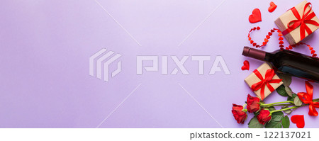 Valentine's day composition with red wine, rose flower and gift box on table. Top view, flat lay. Holiday concept 122137021