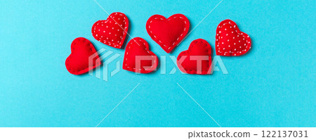 Composition of textile red hearts on colorful background with empty space for your design. Top view of St. Valentine's day concept 122137031
