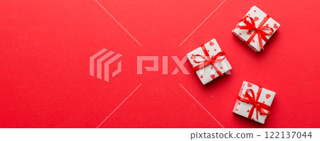 Valentine day composition: red gift box with bow and heart. Christmas present. View from above. Space for text. Holday greeting card 122137044