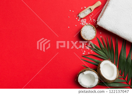 Coconut with jars of coconut oil and cosmetic cream on colored background. Top view. Free space for your text. Natural spa coconut cosmetics and organic treatment concept Coconut Spa composition Coconut with jars of coconut oil and cosmetic cream on colored background. Top view. Free space for your text. Natural spa coconut cosmetics and organic treatment concept Coconut Spa composition 122137047