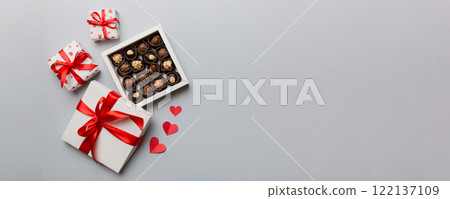 Delicious chocolate pralines in red box for Valentine's Day. Heart shaped box of chocolates top view with copy space Delicious chocolate pralines in red box for Valentine's Day. Heart shaped box of chocolates top view with copy space 122137109