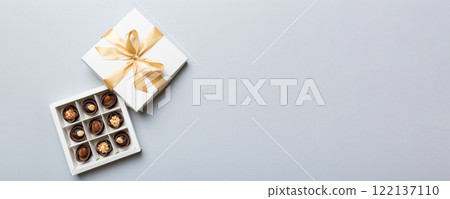 White box with chocolates candies and golden tape. top view with copy space White box with chocolates candies and golden tape. top view with copy space 122137110