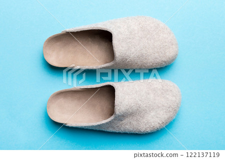 Warm winter women woolen slippers on colored background. Copy space for text Warm winter women woolen slippers on colored background. Copy space for text 122137119