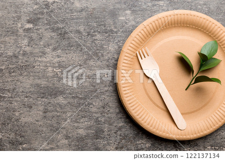 set of empty reusable disposable eco-friendly plates, cups, utensils on light white colored table background. top view. Biodegradable craft dishes. Recycling concept. Close-up set of empty reusable disposable eco-friendly plates, cups, utensils on light white colored table background. top view. Biodegradable craft dishes. Recycling concept. Close-up 122137134