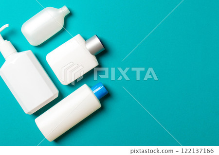 Set of White Cosmetic containers isolated on colored background, top view with copy space. Group of plastic bodycare bottle containers with empty space for you design 122137166