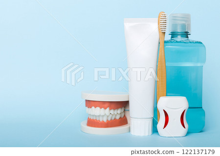 Mouthwash and other oral hygiene products on colored table top view with copy space. Flat lay. Dental hygiene. Oral care kit. Dentist concept Mouthwash and other oral hygiene products on colored table top view with copy space. Flat lay. Dental hygiene. Oral care kit. Dentist concept 122137179