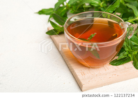 Cup of mint tea on table background. Green tea with fresh mint top view with copy space Cup of mint tea on table background. Green tea with fresh mint top view with copy space 122137234