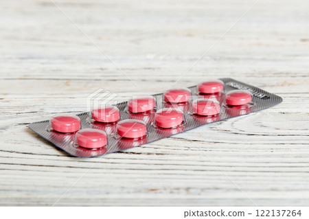 Blister package with Vitamin on color background. Medicine pills on a light background. Medicines and prescription pills flat lay background. pink medical tablets in blister 122137264
