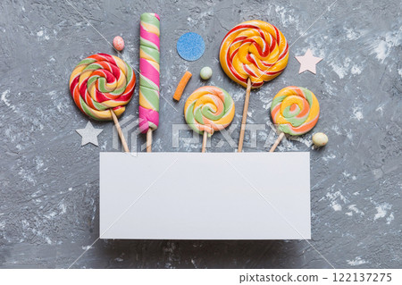 Flat lay holiday composition. Paper blank, lollipop, birthday decorations on Colored background. Top view, copy space for text Flat lay holiday composition. Paper blank, lollipop, birthday decorations on Colored background. Top view, copy space for text 122137275