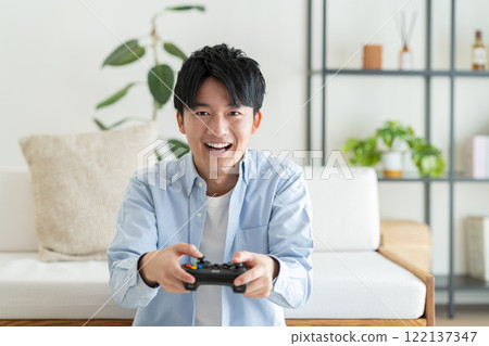 Young man playing video games 122137347