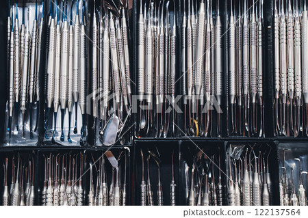 row of many basic stainless steel dental tools supplies on display in boxes 122137564