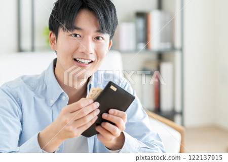 Young man holding a wallet Young man holding a wallet 122137915
