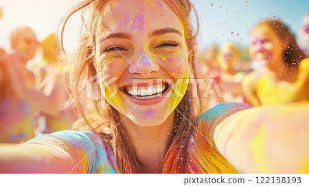 A joyful tourist woman covered with colored gulal powder make selfi, celebrating Holi outdoors 122138193