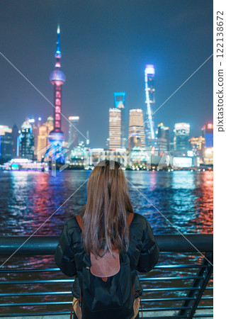 woman traveler visiting in Shanghai, China. Female Tourist with backpack sightseeing Shanghai view of Lujiazui in The Bund of Shanghai. landmark and popular for tourism attractions. Vacation concept 122138672