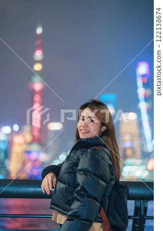 woman traveler visiting in Shanghai, China. Female Tourist with backpack sightseeing Shanghai view of Lujiazui in The Bund of Shanghai. landmark and popular for tourism attractions. Vacation concept 122138674