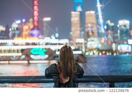 woman traveler visiting in Shanghai, China. Female Tourist with backpack sightseeing Shanghai view of Lujiazui in The Bund of Shanghai. landmark and popular for tourism attractions. Vacation concept woman traveler visiting in Shanghai, China. Female Tourist with backpack sightseeing Shanghai view of Lujiazui in The Bund of Shanghai. landmark and popular for tourism attractions. Vacation concept 122138676