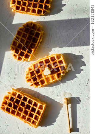 Delicious waffles topped with a touch of honey on a bright background in the morning light 122138842