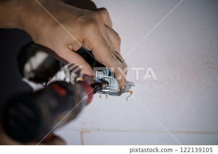 Electrical Installation: A Close-Up of Hands Installing a Wall Outlet 122139105