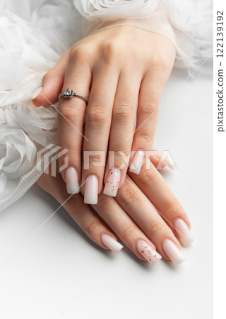 Bride showing her beautiful white nails and engagement ring Bride showing her beautiful white nails and engagement ring 122139192