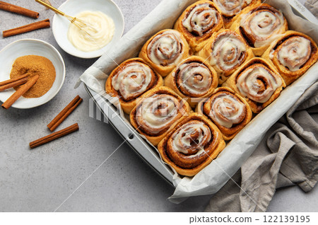 Freshly baked cinnamon rolls with cream cheese frosting in baking pan Freshly baked cinnamon rolls with cream cheese frosting in baking pan 122139195