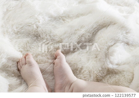 Legs infant baby lying on white bed. 122139577