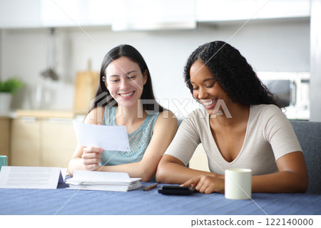 Happy interracial roommates accounting at home 122140000