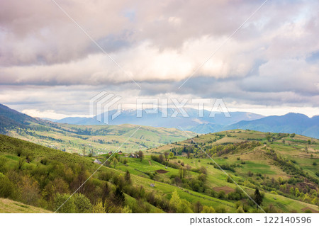 mountain landscape in spring. wonderful distant ridge. countryside scenery with rolling hills. sky with clouds in evening light. amazing springtime 122140596