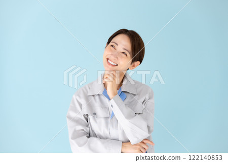 Woman, work clothes, thinking, smiling Woman, work clothes, thinking, smiling 122140853