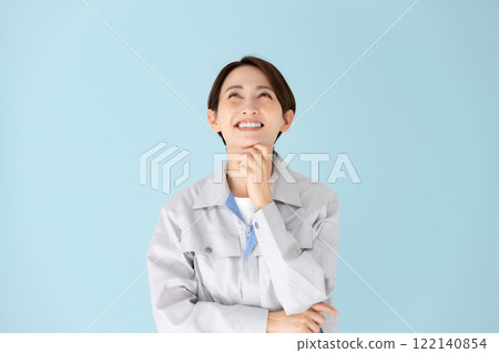 Woman, work clothes, thinking, smiling Woman, work clothes, thinking, smiling 122140854